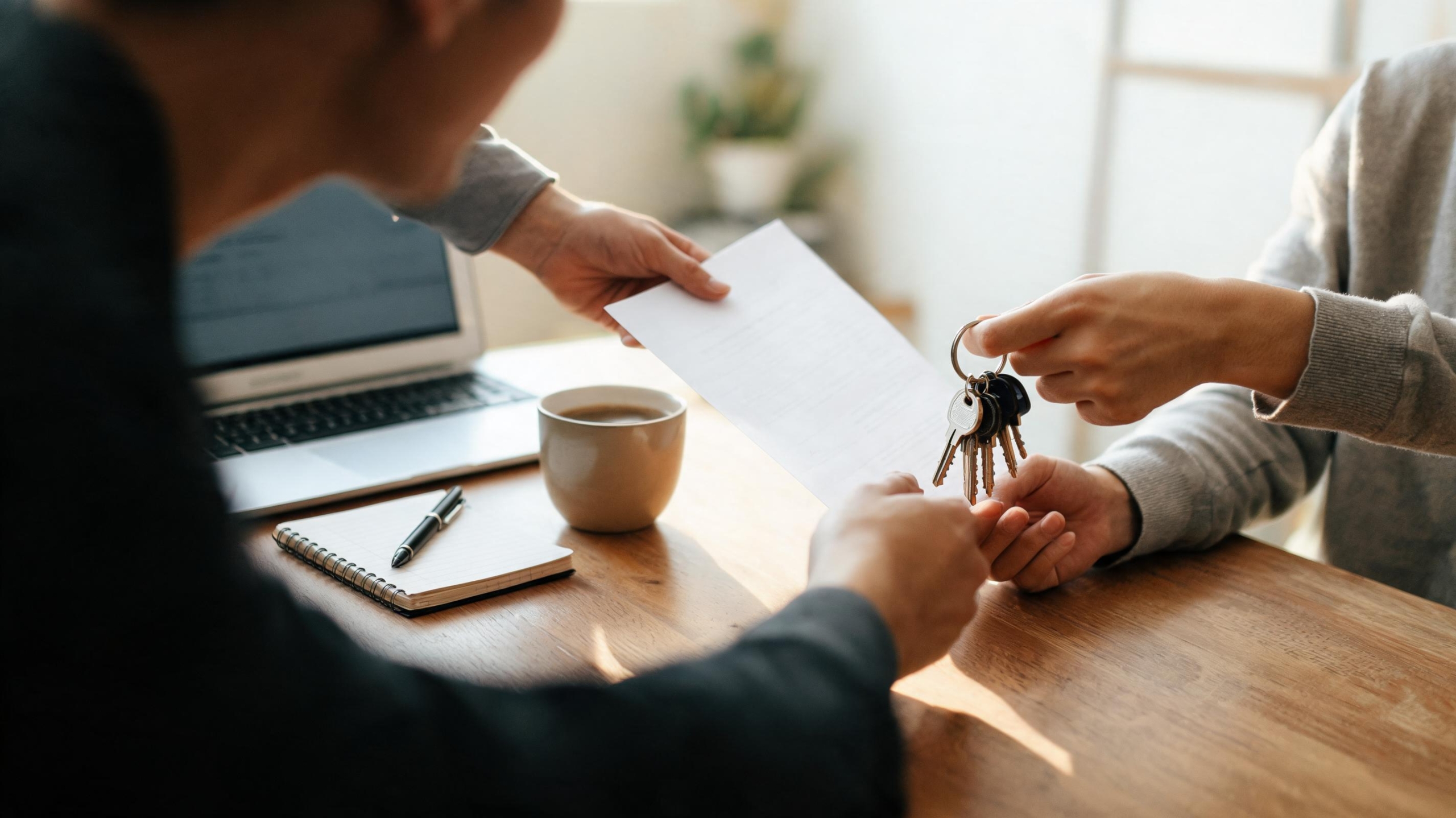 Founder handing a printed checklist and keys to a team member across a desk